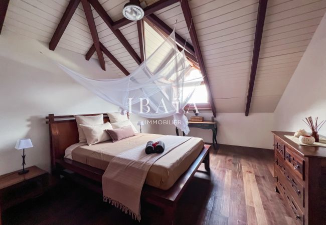 Large bedroom with exposed framework and tropical wood furniture