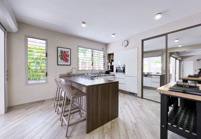 View of the fully equipped American kitchen and the central island with high chairs