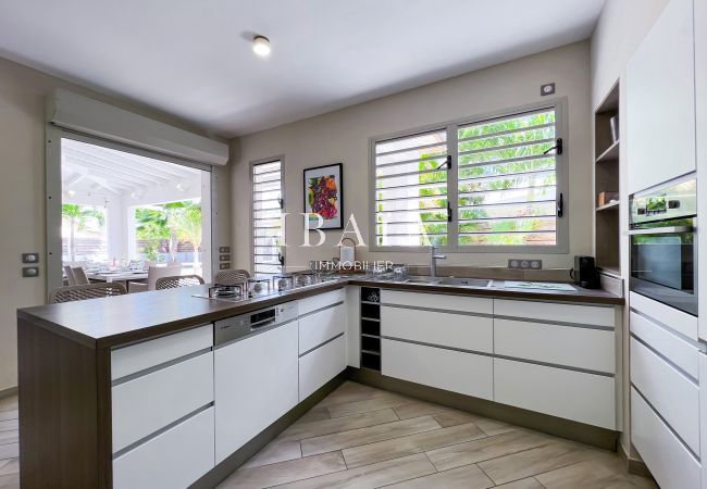 View of the fully equipped American kitchen and the central island with high chairs