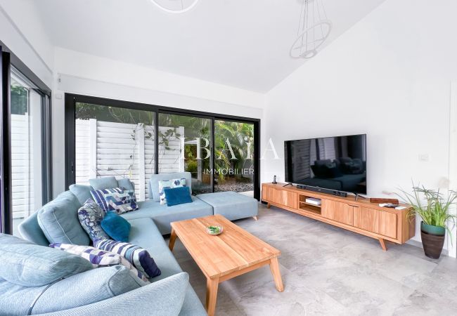 Living room with TV and large windows to the infinity pool and outdoor terrace