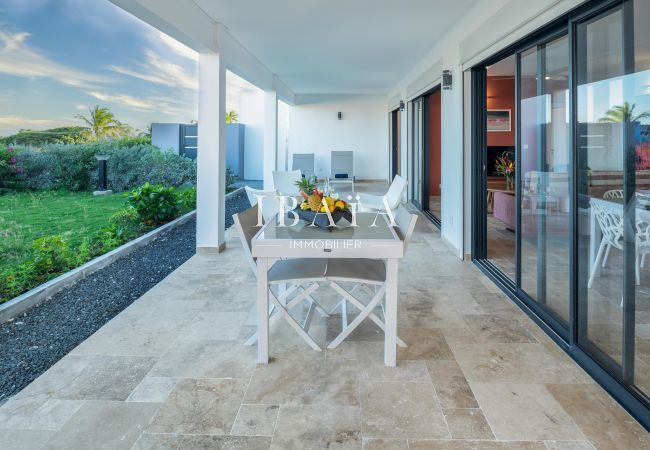 Spacious terrace of a modern house overlooking the garden with sliding glass door.