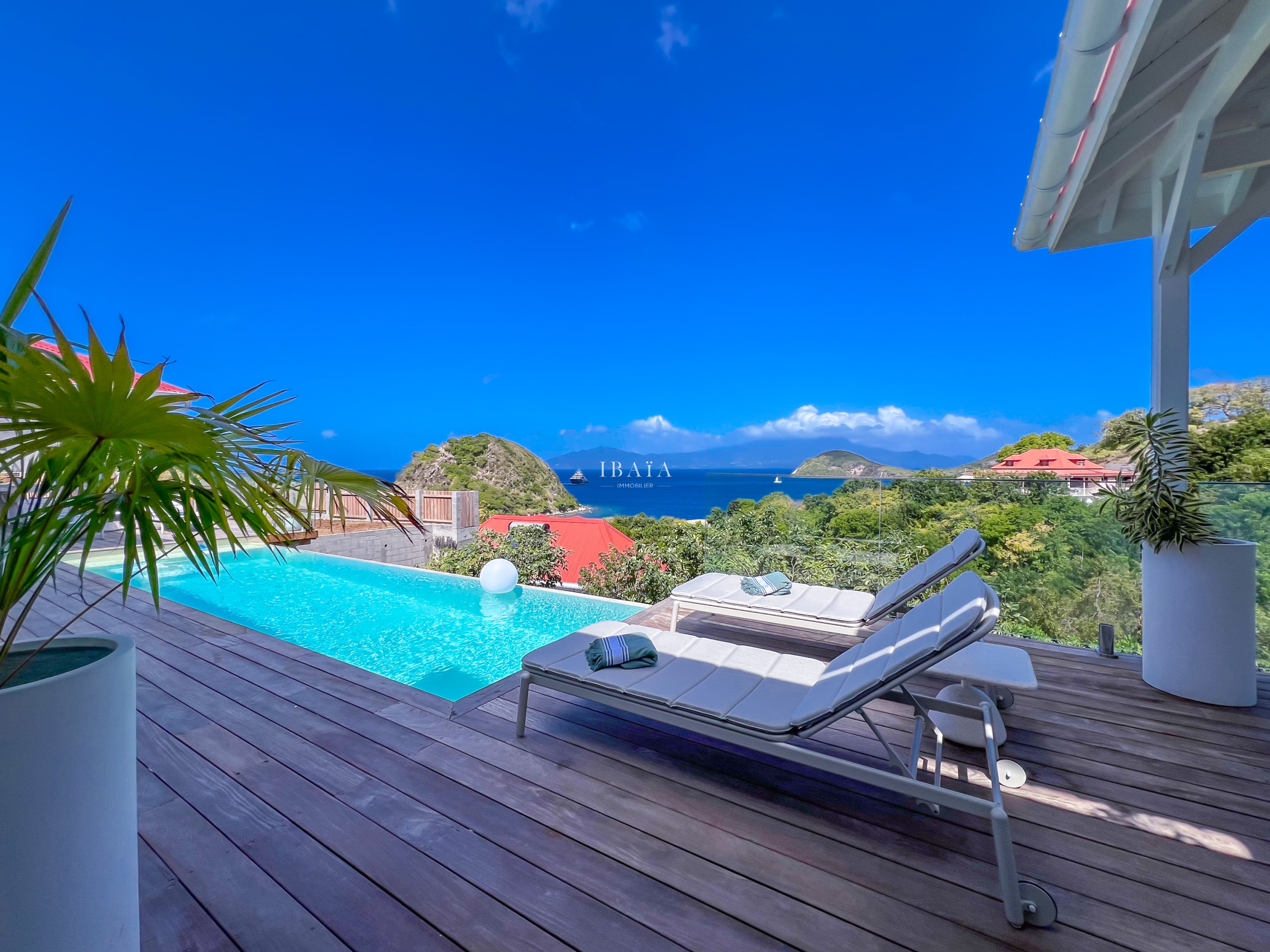 Sun lounger facing a pool and panoramic sea view