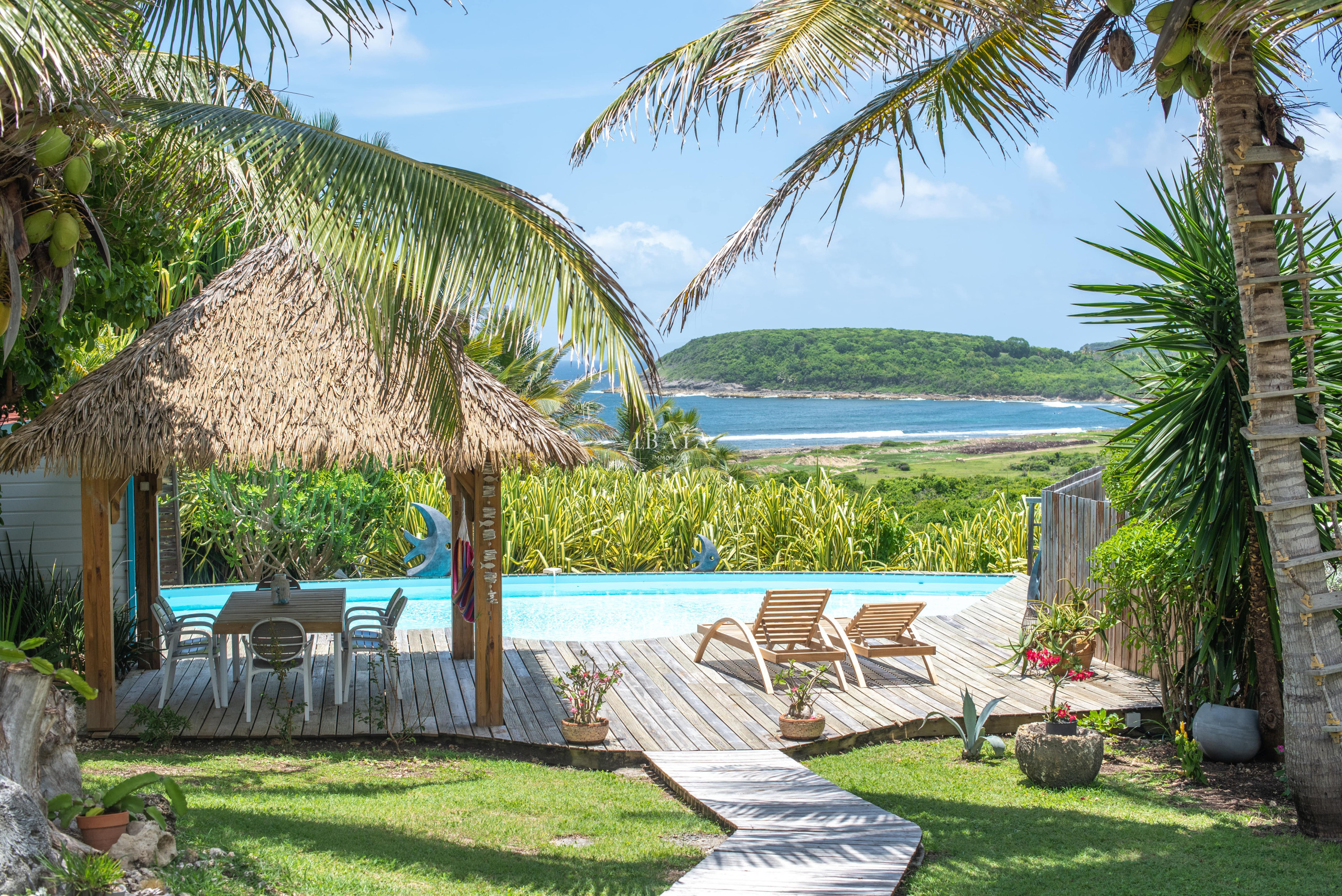 Wooden deck, tiki hut and loungers facing the ocean