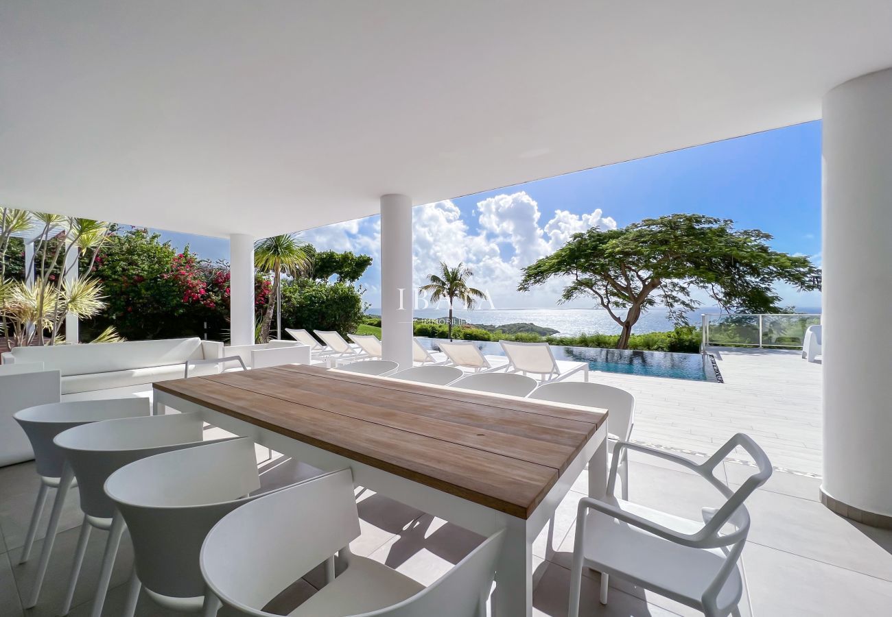Dining table for 10 persons located on the terrace with view on the pool and the sea