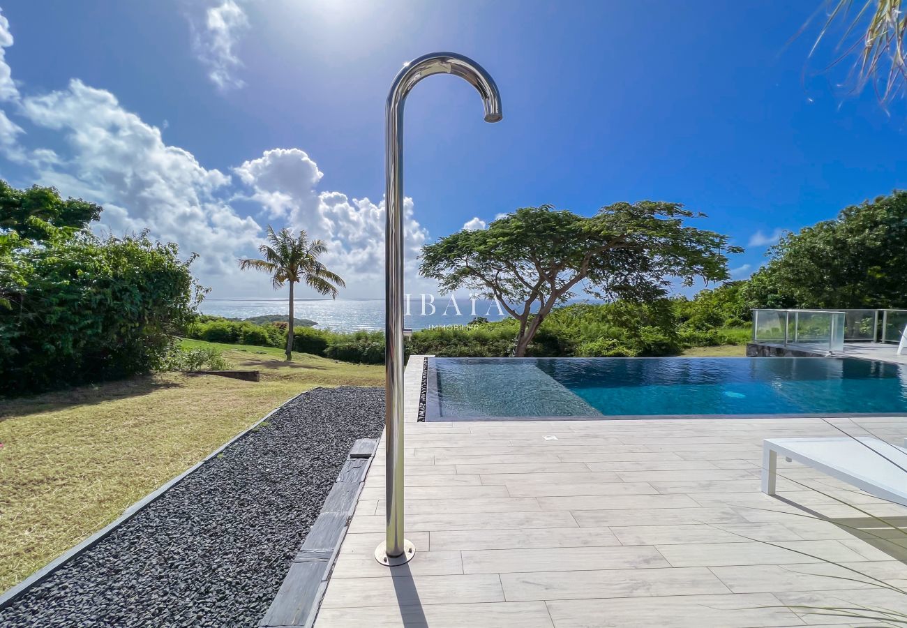 Outdoor shower and infinity pool with ocean view