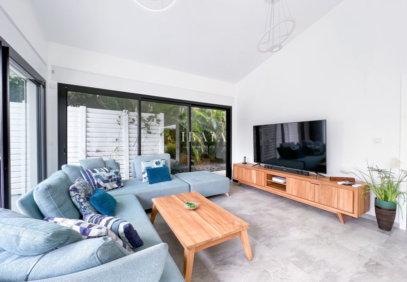 Living room with TV and large windows to the infinity pool and outdoor terrace