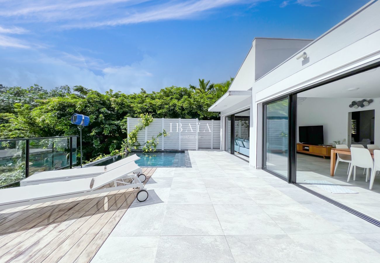 View on the outside terrace, the swimming pool and its 2 deckchairs and view on the dining room and the living room open on the outside thanks to larg