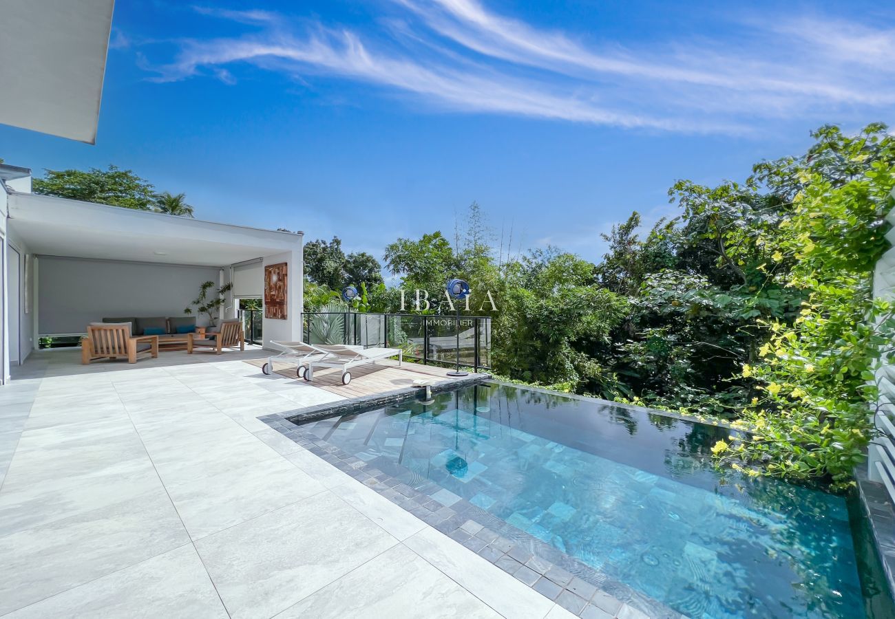 Outdoor living room and splendid infinity pool inspired by the style of Bali