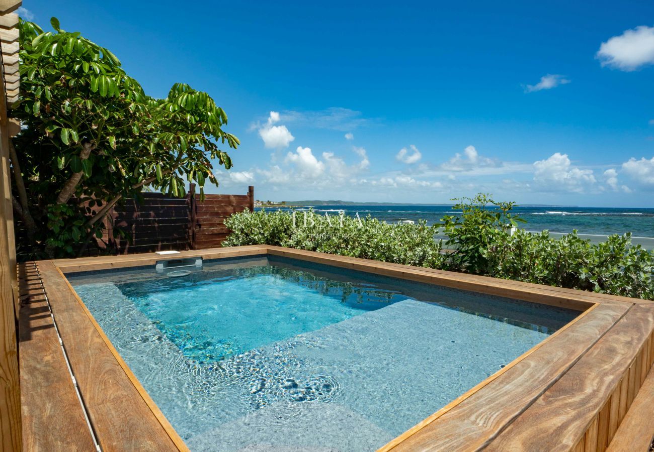 View of the seaside swimming pool with wooden formwork in our top-of-the-range villa in the West Indies