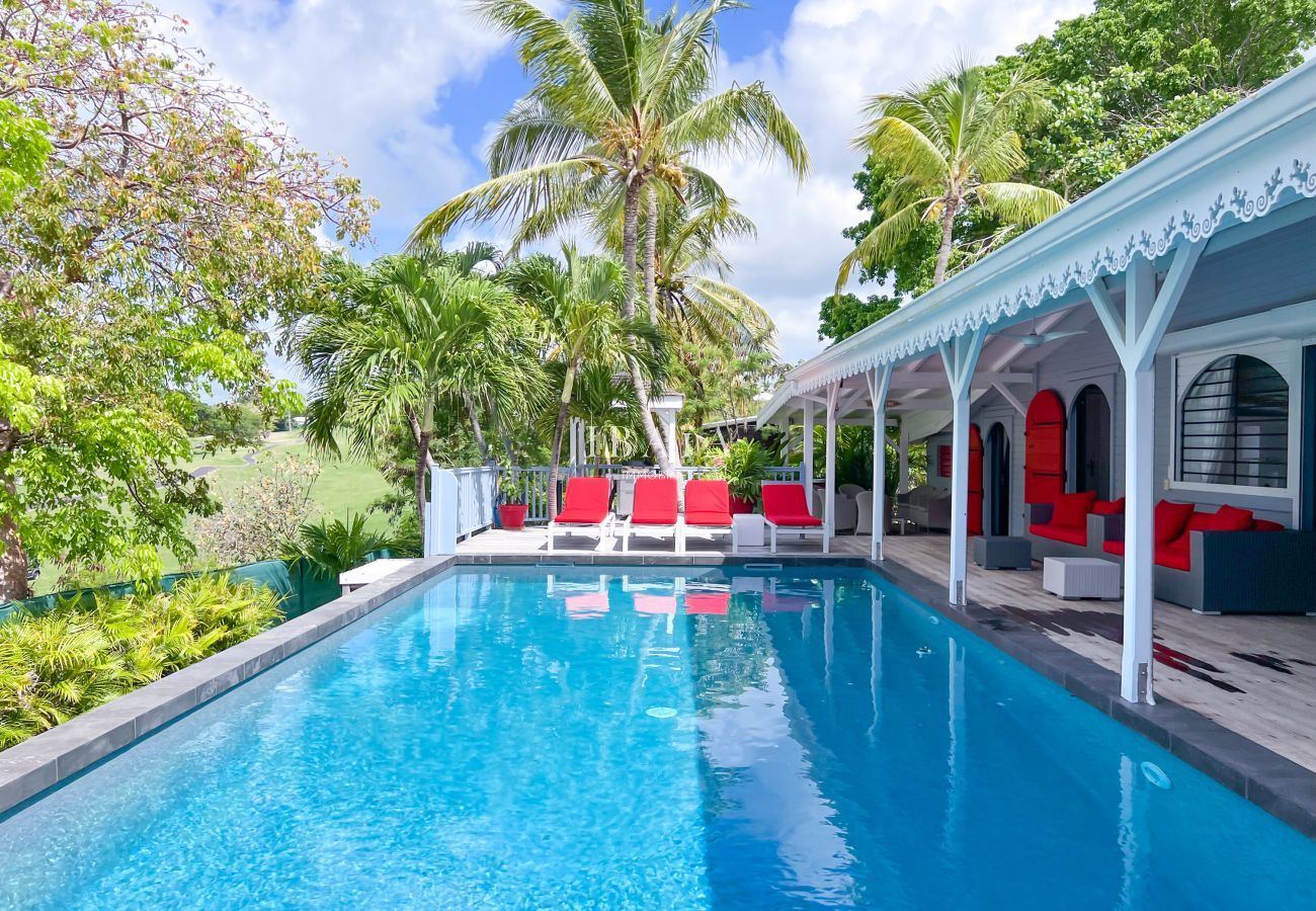 Red deckchairs by the pool on a wooden terrace - Luxury villa in the West Indies