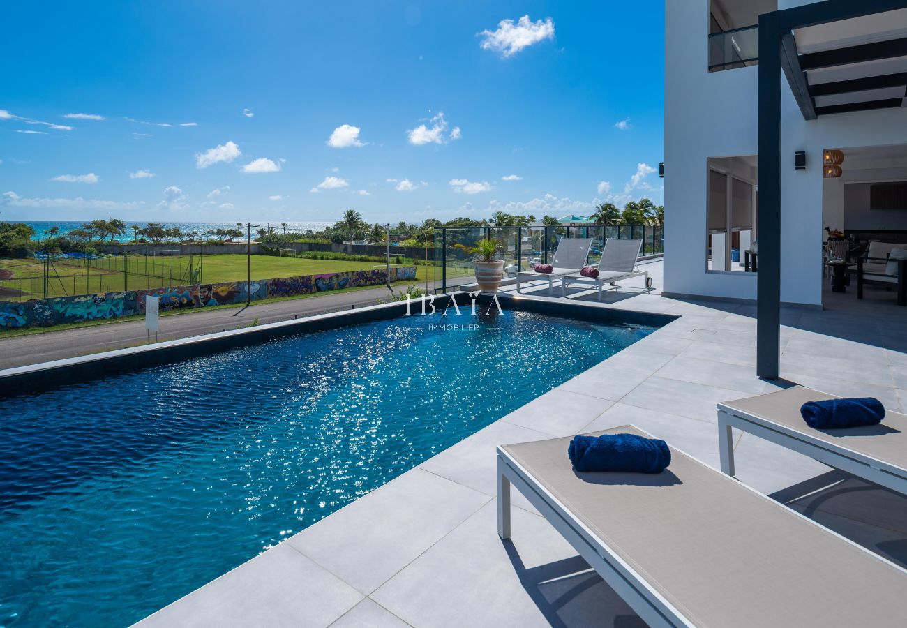 Luxurious pool of a modern house with ocean view and graffiti wall.