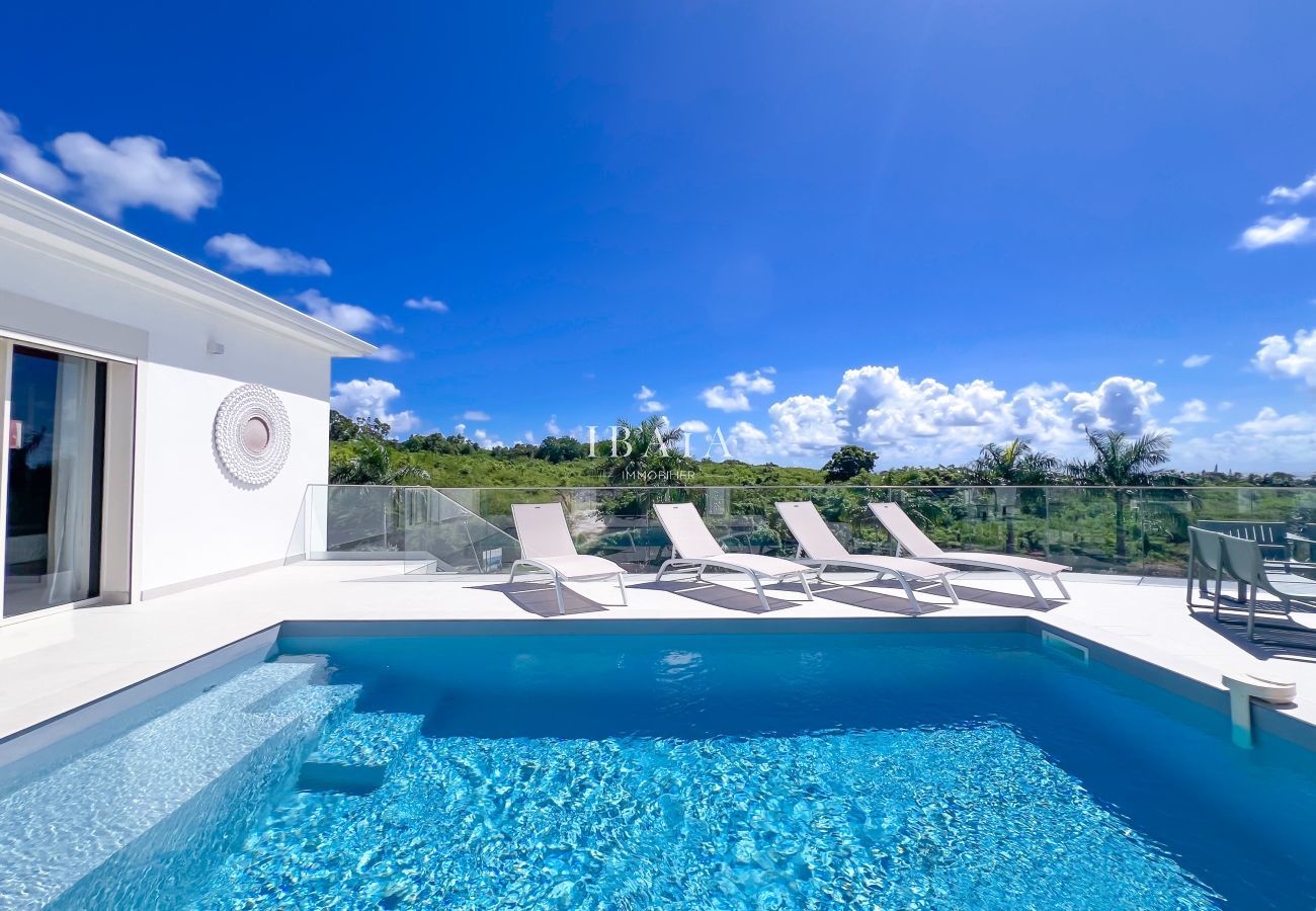 Turquoise pool and loungers facing nature
