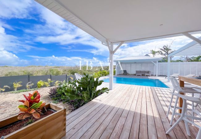 Vista del jardín y la piscina bajo la terraza de una villa de alta gama en las Antillas, para disfrutar de una relajante experiencia al aire libre.