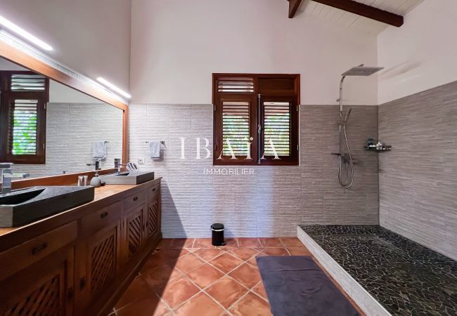 Amplio cuarto de baño con ducha a ras de suelo y carpintería de madera vista