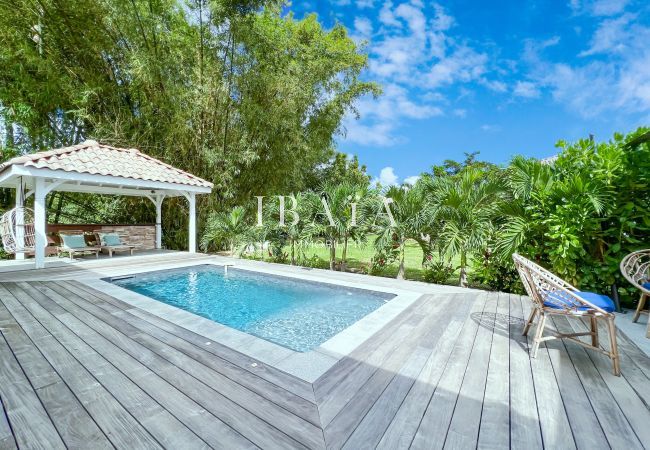 Vista de la piscina y del patio con muebles de jardín y tarima de madera