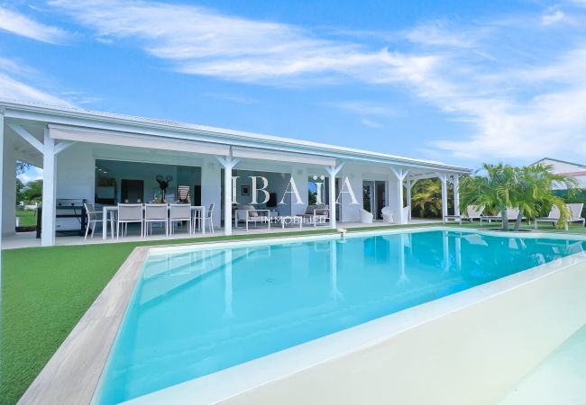 Gran piscina infinita al borde de la terraza con mesa de comedor para 8 personas