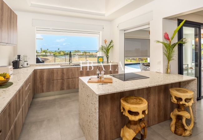 Cocina moderna con encimera de mármol, vista a la piscina.