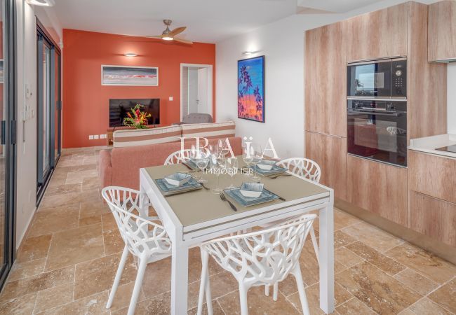 Interior moderno de un comedor con pared naranja, sofá y mesa de cena.