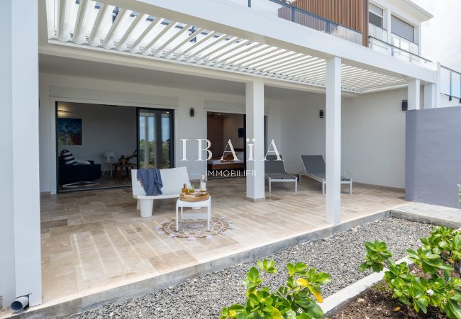 xterior de una casa moderna con terraza, muebles de exterior y vista a una habitación interior.