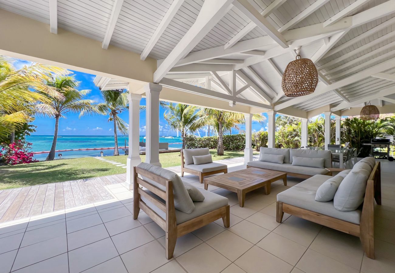 Salón exterior en la terraza sombreada con vistas al mar y a la laguna de Saint-François, en una villa de lujo en las Antillas