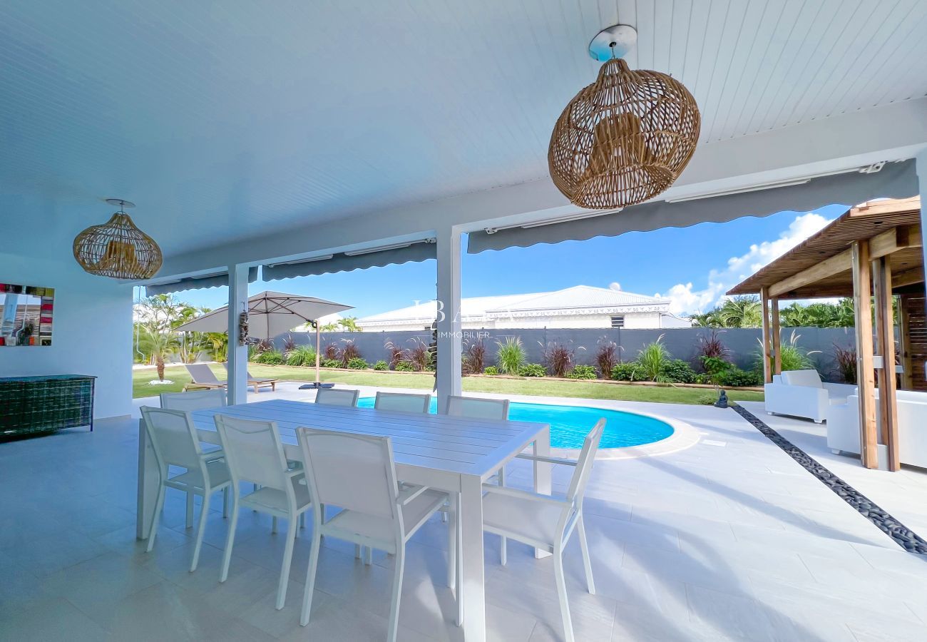 Vista de una mesa de comedor de 8 plazas con magníficas vistas a la piscina en una villa de alta gama en las Antillas.