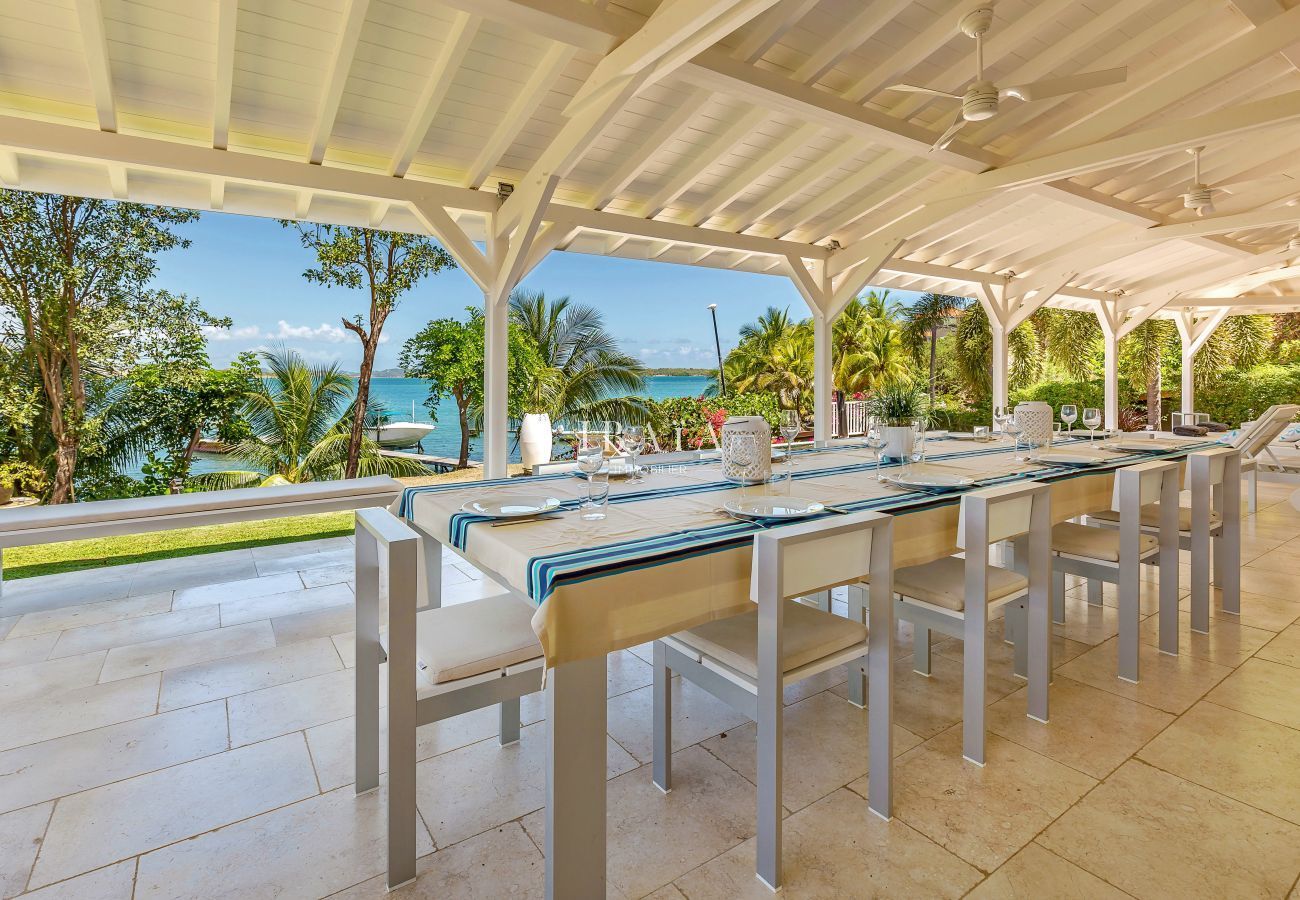 Gran mesa de comedor para 10 personas en la terraza con vistas a la piscina y al mar