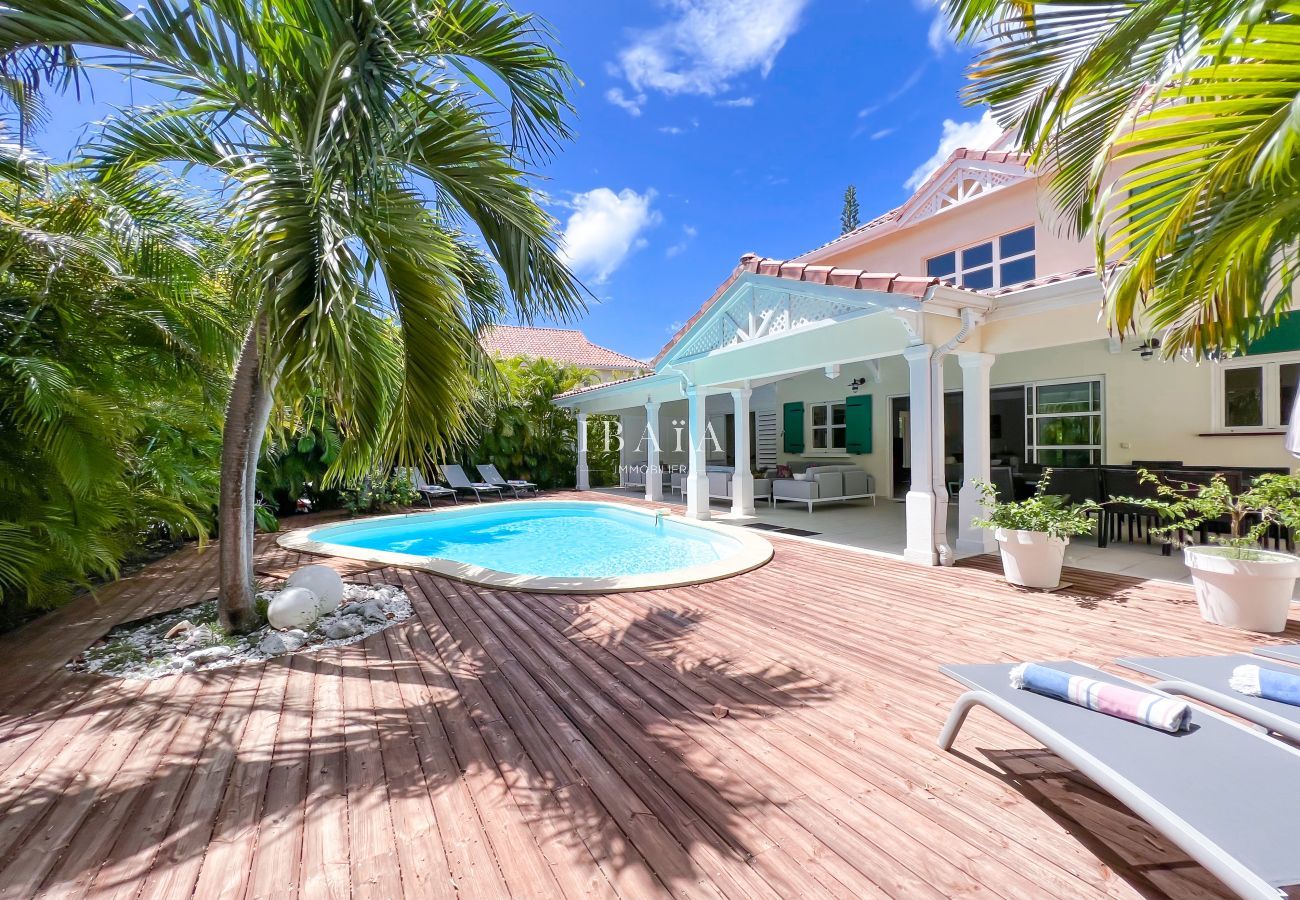 Amplia terraza sombreada situada en un jardín tropical con piscina privada