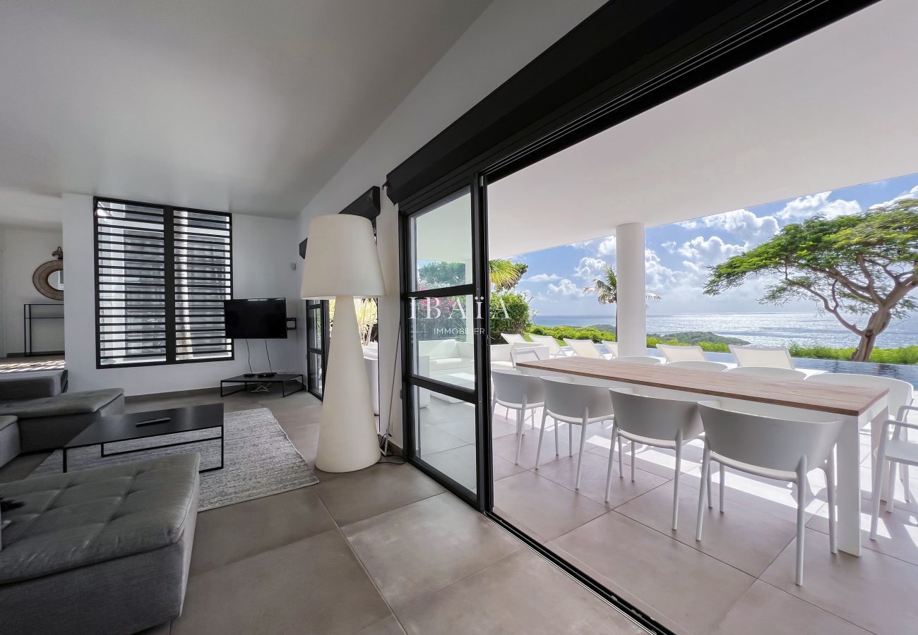 Desde el salón interior, la vista de la mesa del comedor y de la terraza no tiene obstáculos gracias a las grandes ventanas correderas