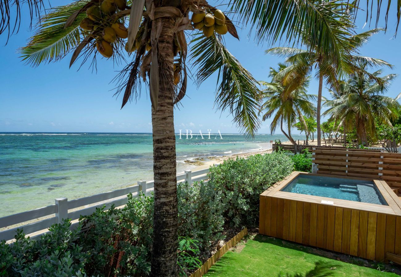 Vista desde el jardín sobre el paseo marítimo y la piscina de nuestra villa de lujo en las Antillas.