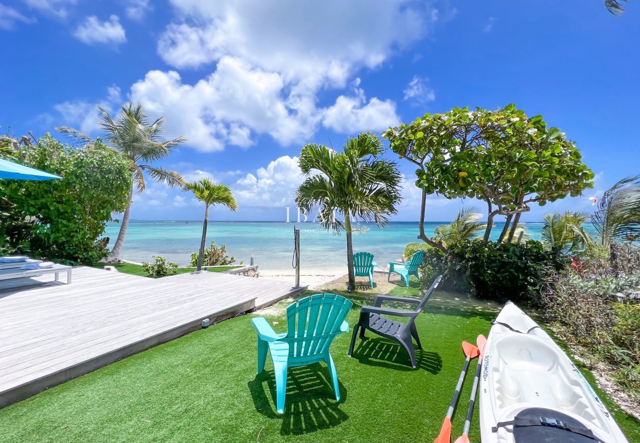 Terraza con sillas de jardín y kayaks, acceso a la playa de arena y al mar de la laguna Saint-François - Villa de lujo en las Antillas francesas
