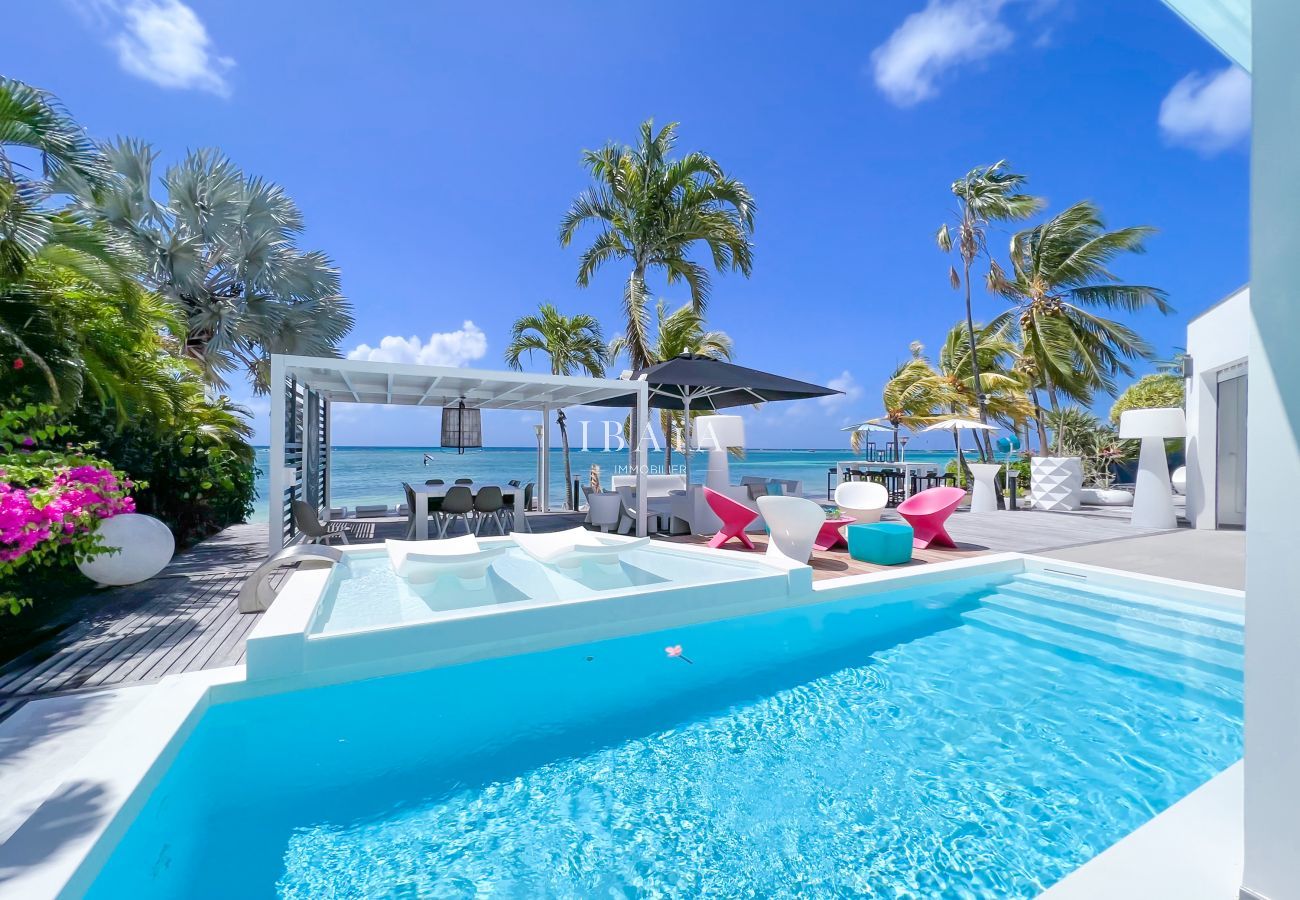 Piscina y terraza con pérgola y mesa de comedor con vistas al mar - Villa de lujo en las Antillas francesas