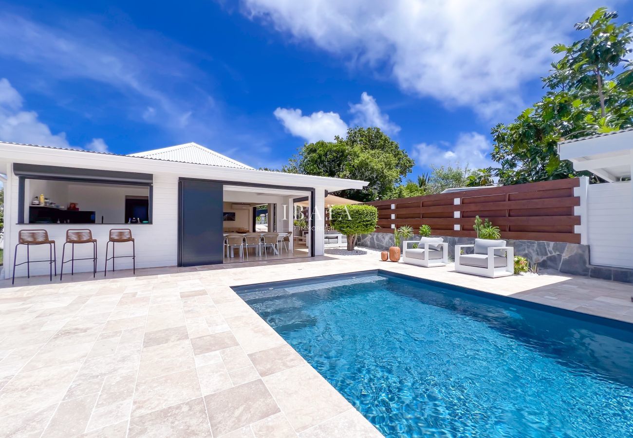 Piscina moderna con bar y salón exterior
