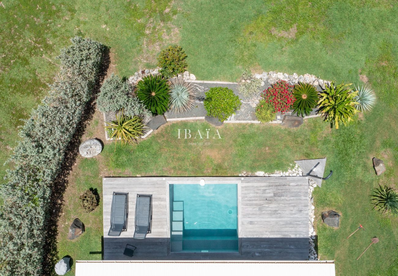 Vista dron de piscina con terraza y jardín decorado