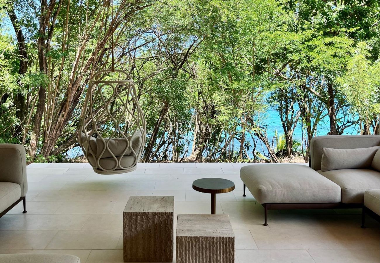 Salón moderno abierto con silla colgante y vista al mar