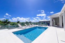 Piscina turquesa y tumbonas bajo el cielo azul