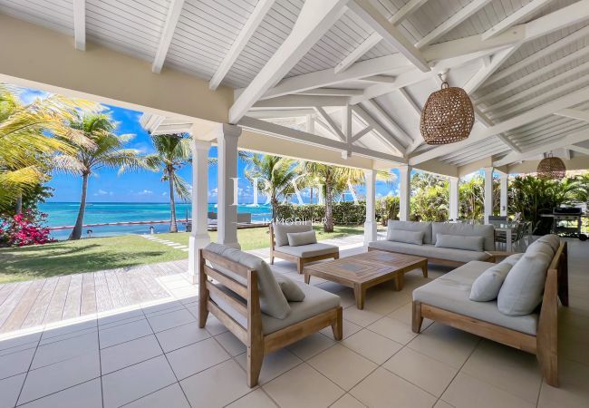 Salon d'extérieur sur la terrasse ombragée offrant une vue sur la mer et le lagon de Saint-François, dans une villa haut de gamme aux Antilles
