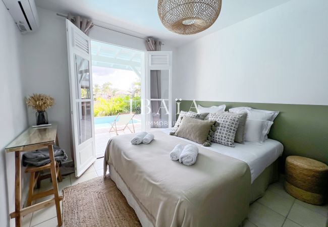 Chambre à coucher avec porte-fenêtres donnant sur la terrasse et la piscine