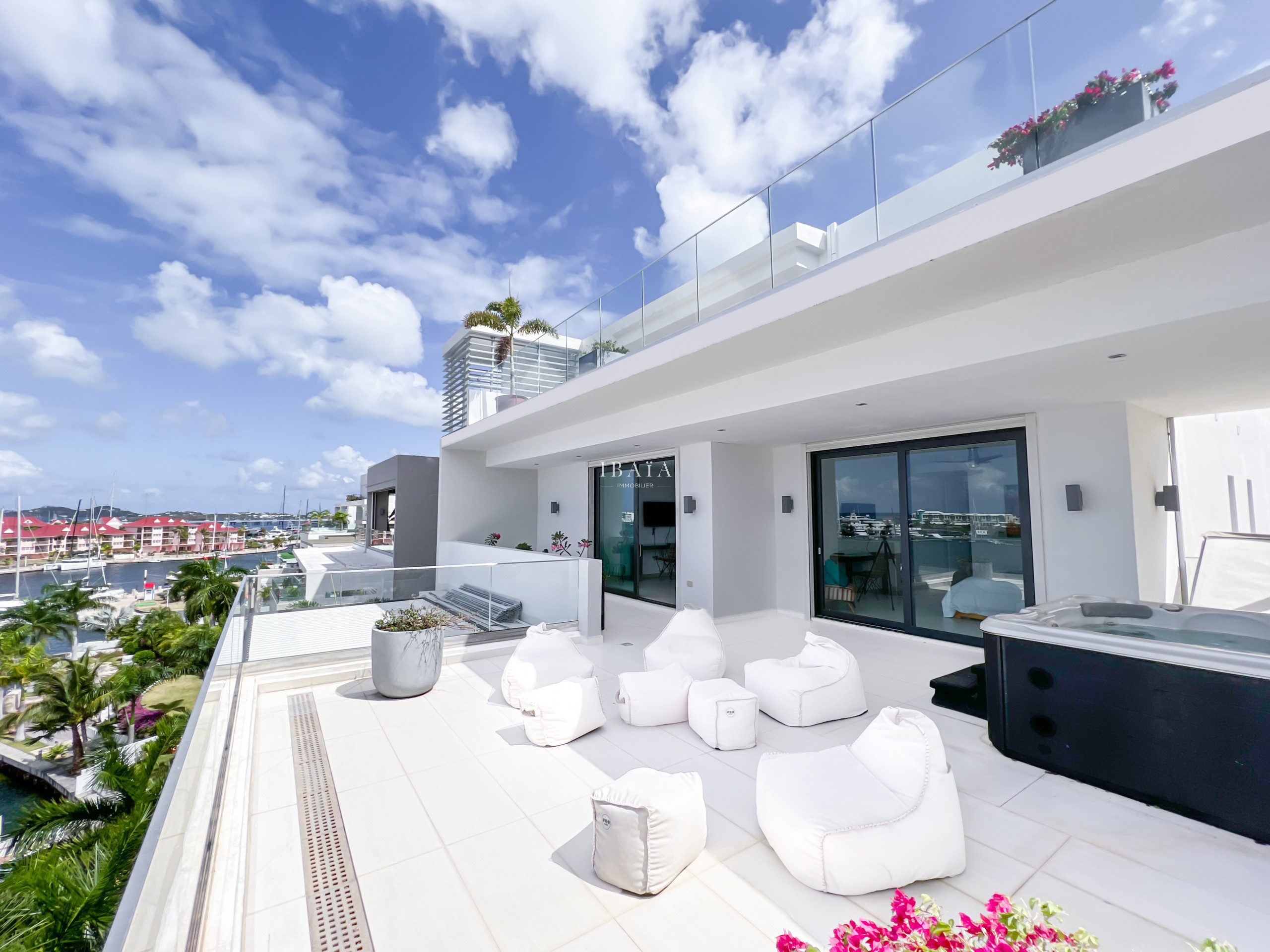 Vue sur la terrasse avec jacuzzi et accès direct aux chambres, petit salon d'extérieur avec vue panoramique sur la terrasse du niveau supérieur du pen