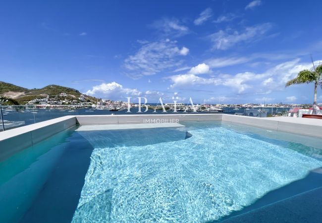 Vue de la piscine sur la terrasse du penthouse offrant une vue sur la baie Simpson Bay, dans une villa haut de gamme aux Antilles
