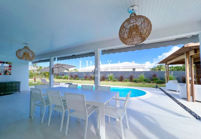 Vue sur une table à manger 8 places avec une magnifique vue sur la piscine dans une villa haut de gamme aux Antilles