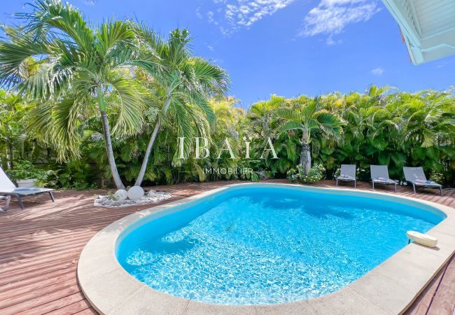 Grande piscine et transat sur un deck en bois