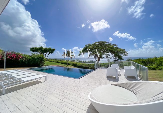 Superbe piscine à débordement avec terrasse et meubles de jardin