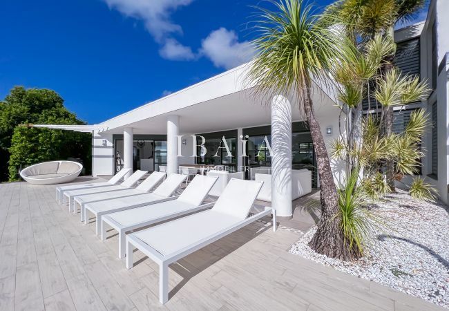 Grande terrasse et jardin tropical devant la piscine à débordement et la vue mer