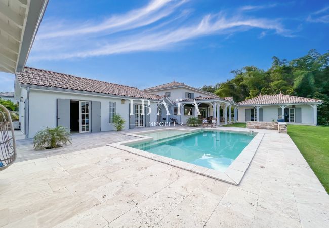 Vue sur la piscine, la terrasse et les différents bungalows de la villa saint alban