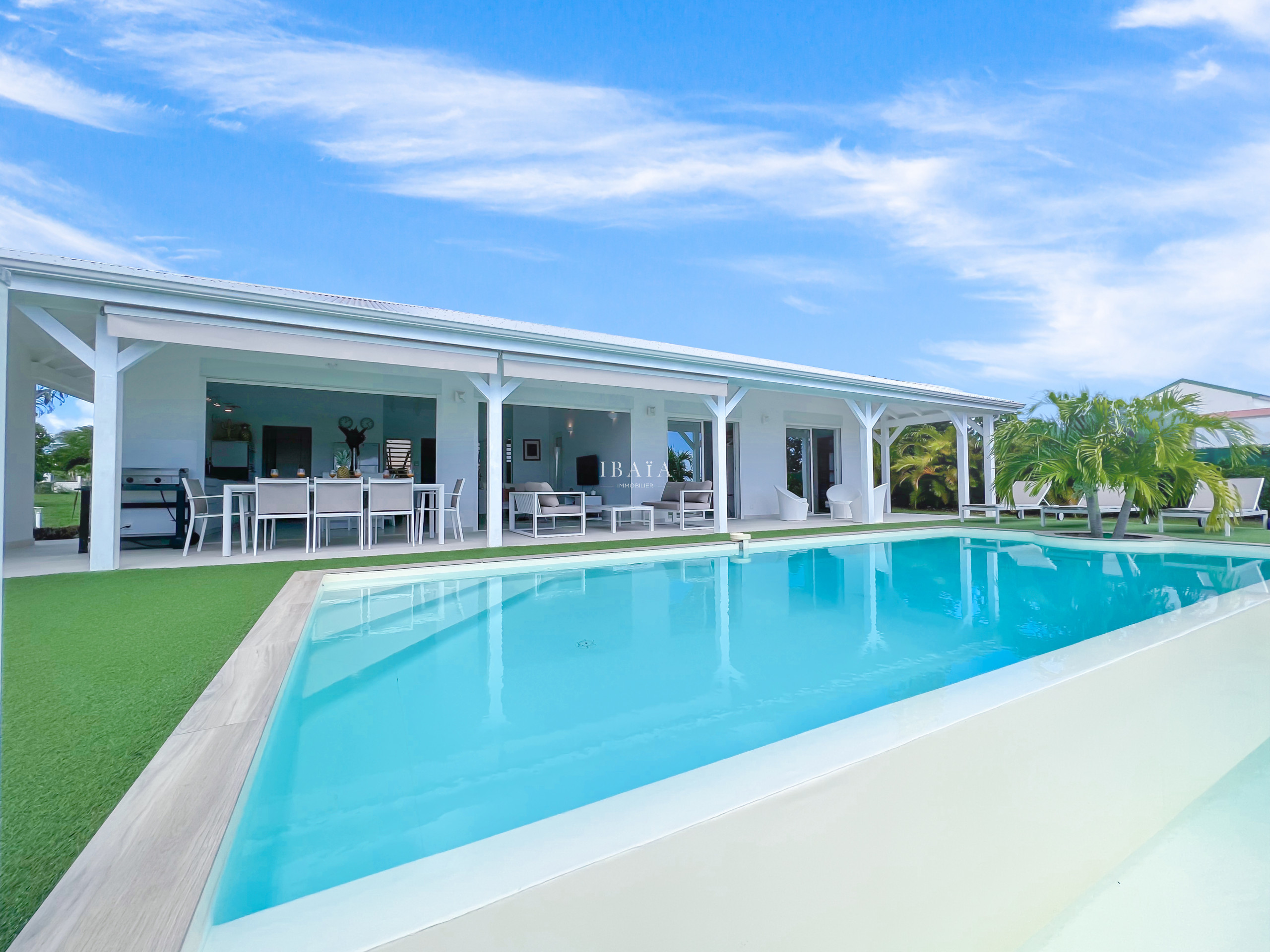 Grande piscine à débordement au selen bord de terrasse avec table à manger 8 personnes