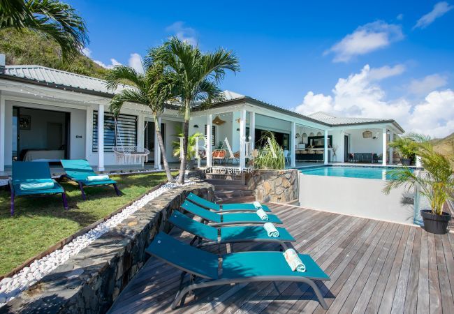 Grande terrasse avec transats disposés autour de la grande piscine