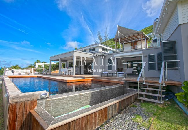 Piscine à débordement avec coffrage en bois et façade villa luxe