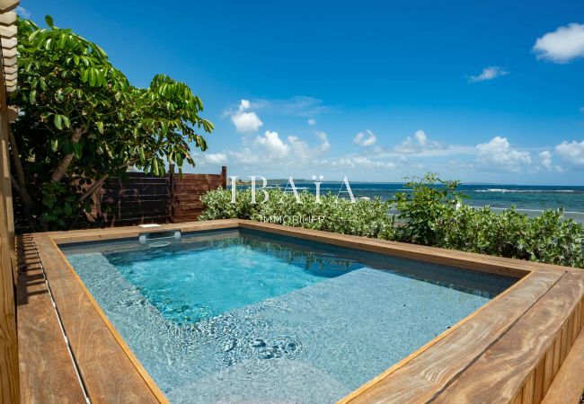 Vue de la piscine en bord de mer avec un coffrage en bois de notre villa haut de gamme aux Antilles