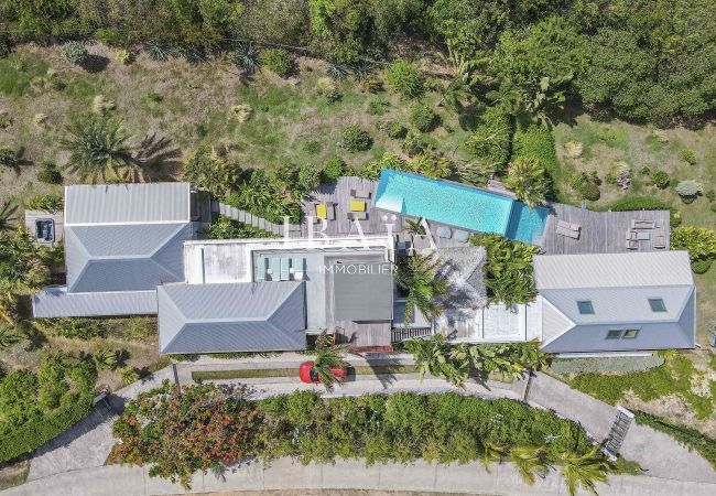 Vue drone de l'ensemble de la villa avec piscine et trois bâtiments, une expérience haut de gamme aux Antilles