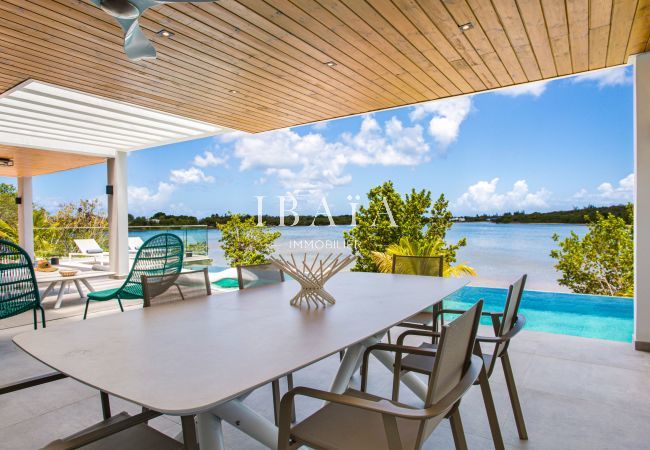 Vue sur la salle à manger sur la terrasse avec vue sur la piscine et la mer dans le fonds dans notre villa haut de gamme aux Antilles